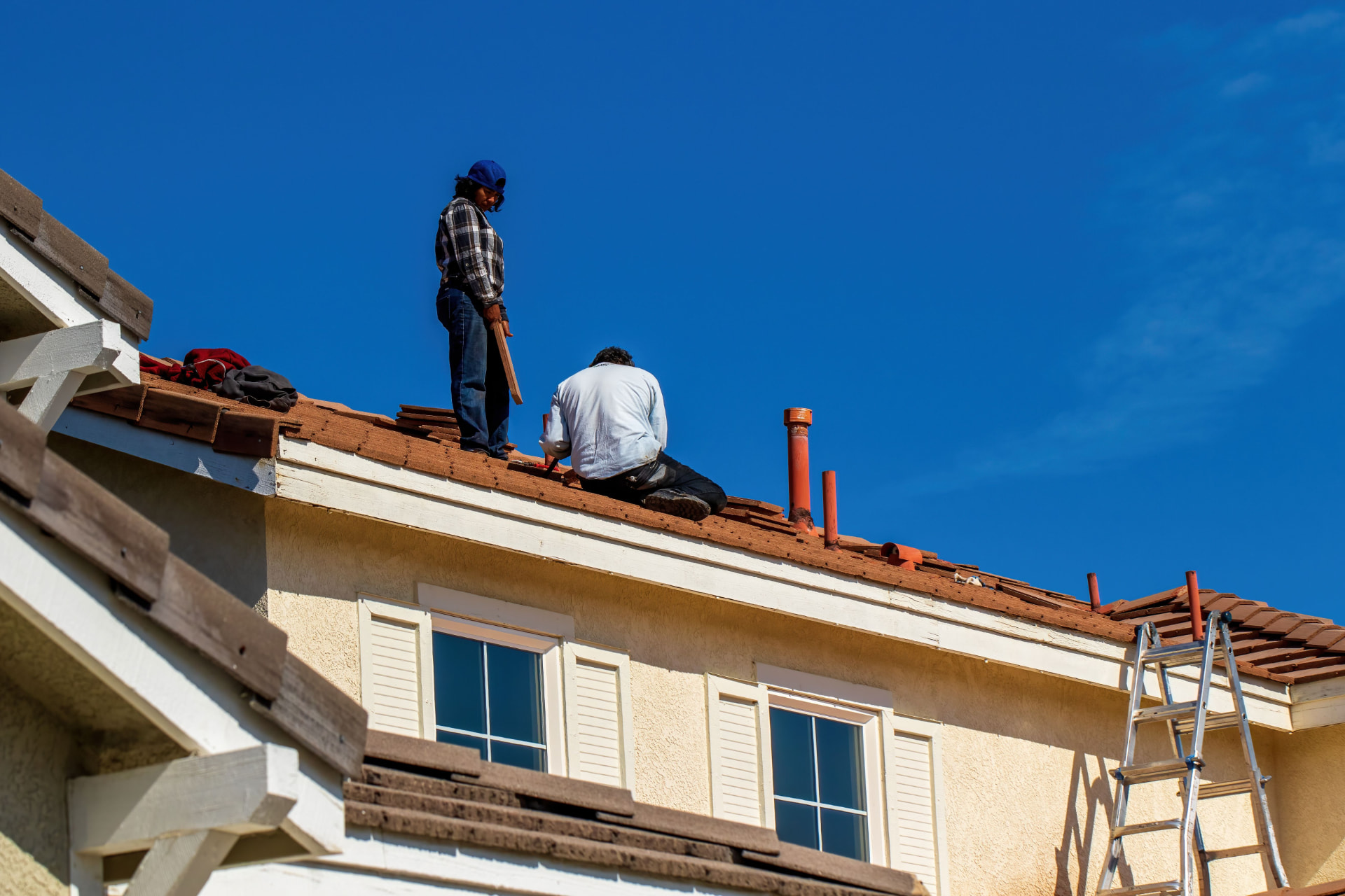 Roofing crew inspecting a tile roof in Phoenix, Arizona